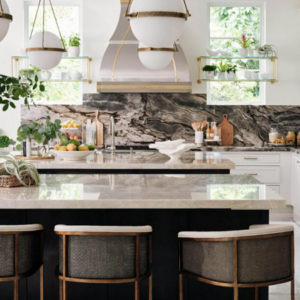 Large white globe pendants and a black and white marble backsplash are seen in this JC Huffman kitchen remodel. Also seen are 2 gray barstools by the island peninsula.