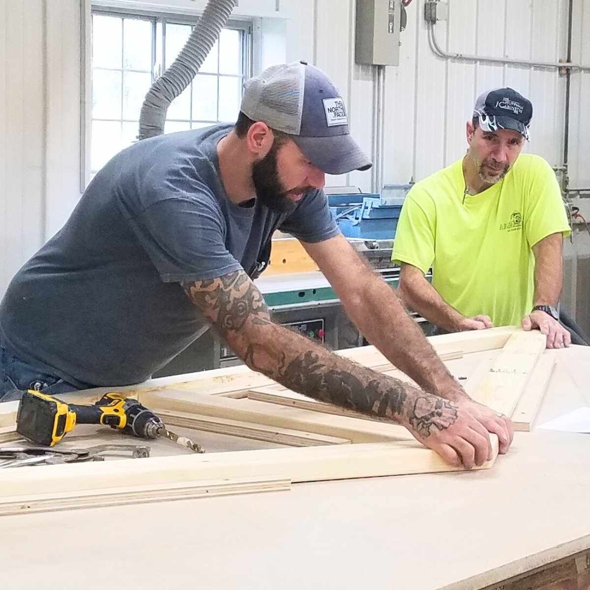 Two carpenters work at JC Huffman Cabinetry.