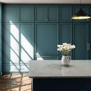 Green kitchen wall cabinets with white island.