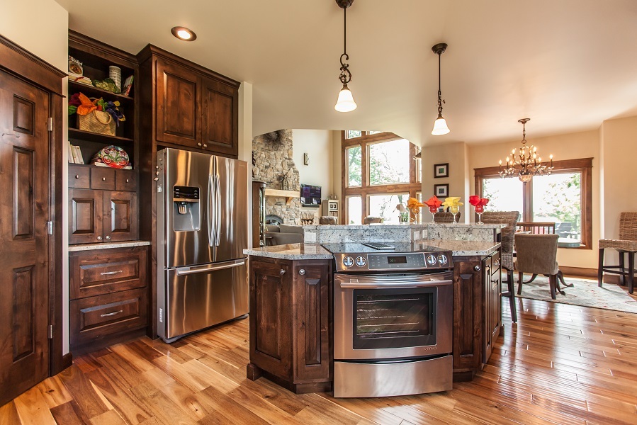 Brindle-stained alder kitchen cabinets with a central island and open dining area in a Fairfield, Iowa home.