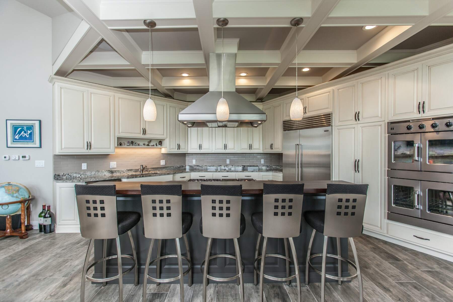 Two-tone kitchen in Mount Pleasant, Iowa, with white perimeter cabinets and an Urbane Bronze island beneath a coffered ceiling.