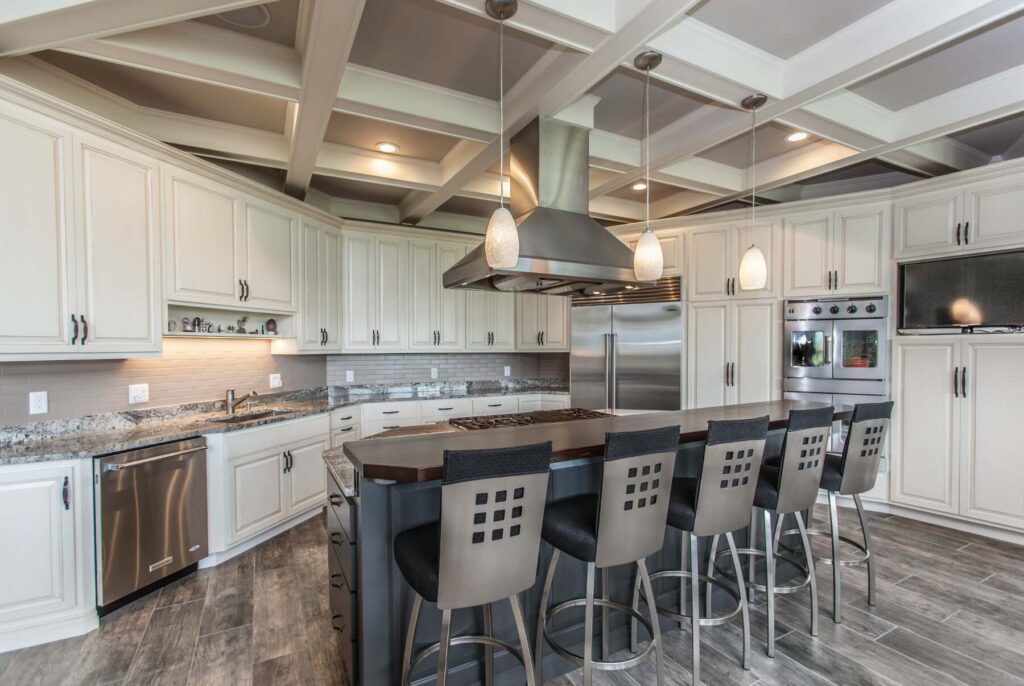 A real-world Mount Pleasant home showcasing two-tone urbane bronze cabinets paired with a warm white perimeter and elegant tile details.