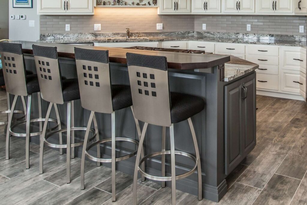 Close view of an Urbane Bronze kitchen island with seating and white perimeter cabinetry in a Mount Pleasant, Iowa, home.